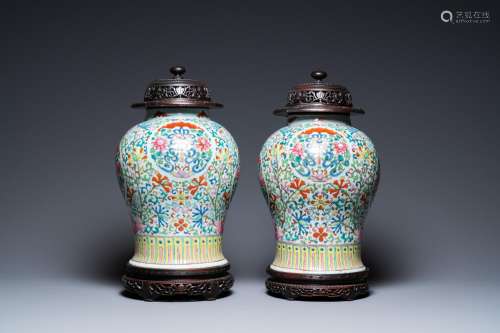 A pair of Chinese famille rose vases with wooden covers and ...