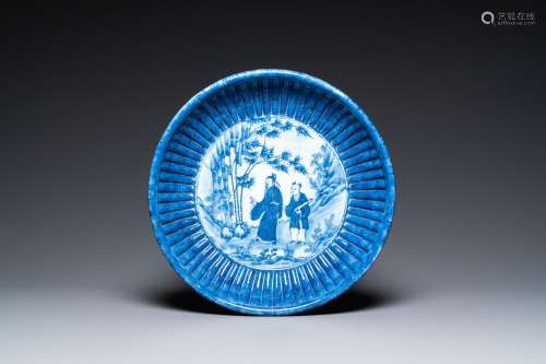 A Chinese ribbed blue and white dish with a scholar and his ...