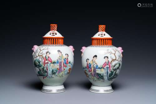 A pair of Chinese famille rose vases with reticulated covers...