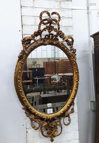 A late Victorian giltwood and gesso oval framed wall mirror,...