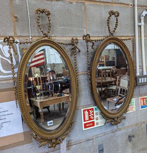 A pair of Edwardian Adam design oval giltwood and gesso wall...