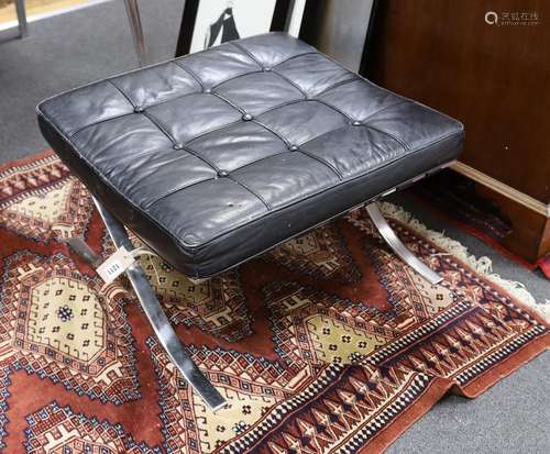 A Barcelona style black leather and chrome footstool, length...