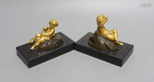 A pair of ormolu putto paperweights on black marble bases,13...