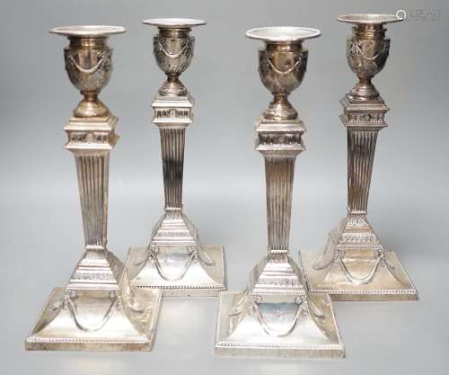 A set of four late Victorian silver candlesticks, with flute...