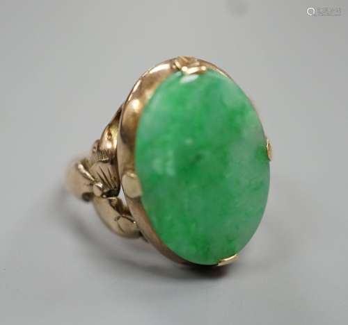 A yellow metal and oval cabochon jade set ring, size K/L, gr...