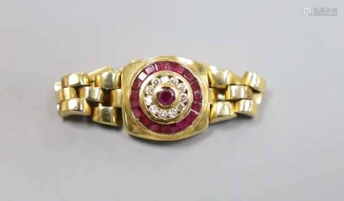 A modern 750, ruby and diamond circular cluster set ring, wi...