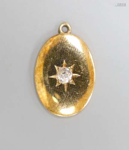 A yellow metal and single stone diamond set oval pendant, 19...