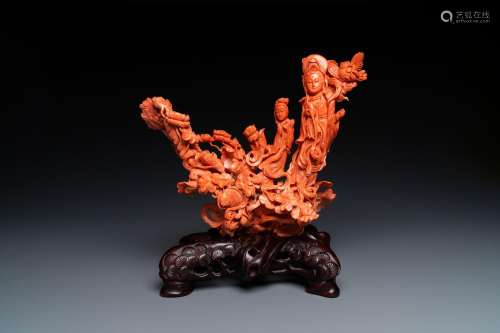 A large Chinese carved red coral group with two ladies surro...