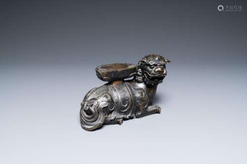 A rare Chinese bronze mythical animal 'Kaiming Shou' holding...