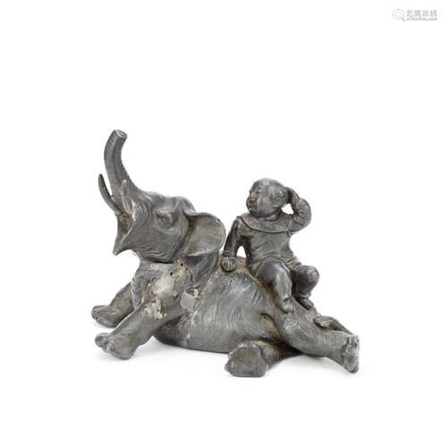 A SILVERED METAL OKIMONO OF A KARAKO ON AN ELEPHANT By Juzan...