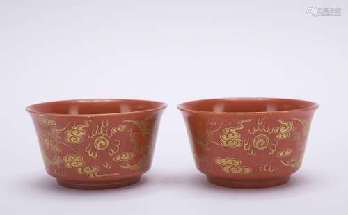 A pair of red-ground 'dragon and phoenix' cup painting in go...