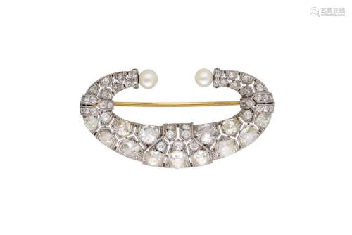 A C-shaped platinum brooch set with diamonds and a cultured ...