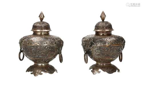 A pair of below legal alloy silver lidded vases with two ear...