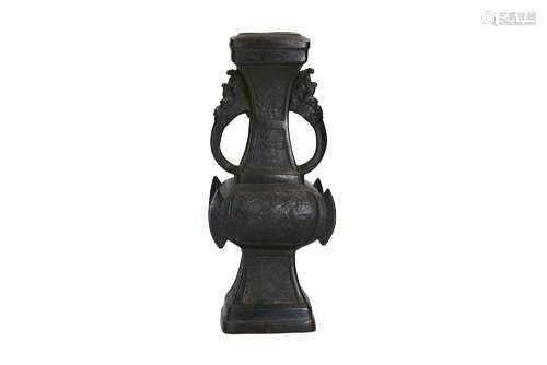 A bronze vase with two handles in the shape of dragon heads ...