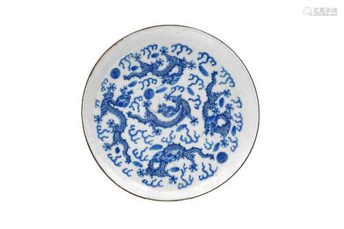 A blue and white porcelain dish with metal rim, decorated wi...