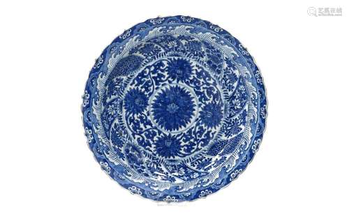 A blue and white porcelain charger with scalloped rim, decor...