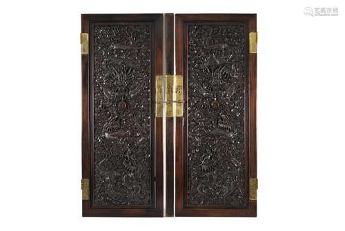 A pair of carved rosewood cabinet doors with brass hinges an...