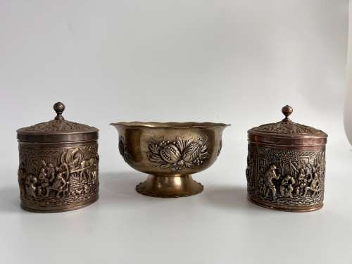 A pair of metal tea cans and a brooded bowl.