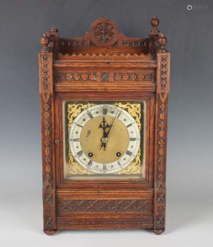 A late 19th century oak mantel clock with eight day movement...