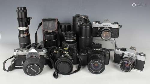 A collection of 35mm cameras and lenses, including Nikon FG-...