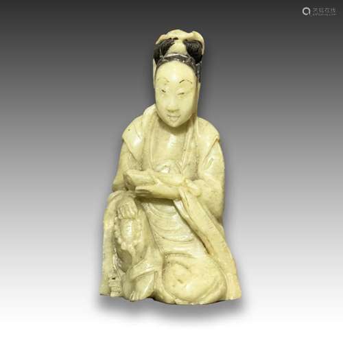 A CHINESE SOAPSTONE FIGURE OF A SEATED GUANYIN, HOLDING PRAY...