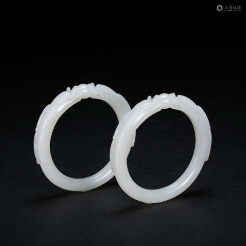 A PAIR OF CHINESE WHITE HETIAN JADE DRAGON BRACELETS FROM QI...