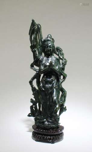 A CARVED SPINACH GREEN GUANYIN STATUE