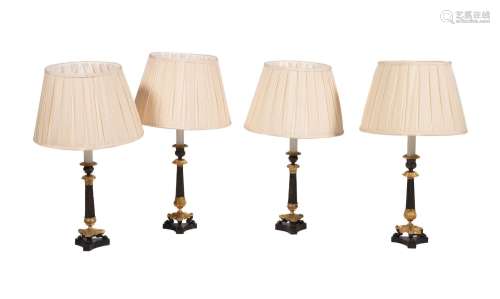 A SET OF FOUR FRENCH BRONZE AND GILT METAL TABLE LAMPS, IN E...