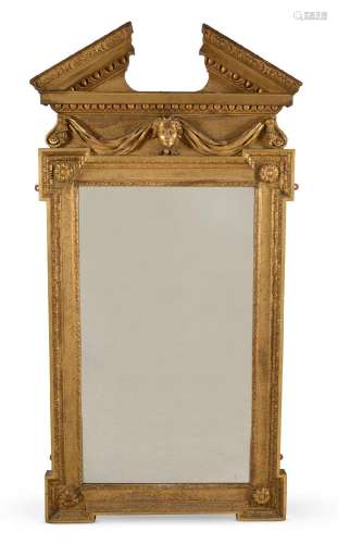 A CARVED GILTWOOD WALL MIRROR, IN GEORGE II STYLE, AFTER DES...