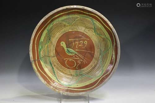 A slipware charger, probably Dutch, dated 1729, the pale bro...