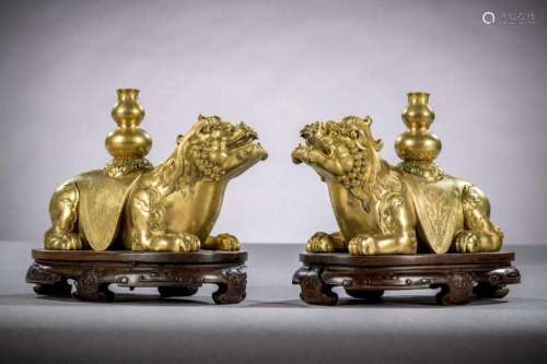 A fine pair of gilt bronze mythical lions on hardwood stands...