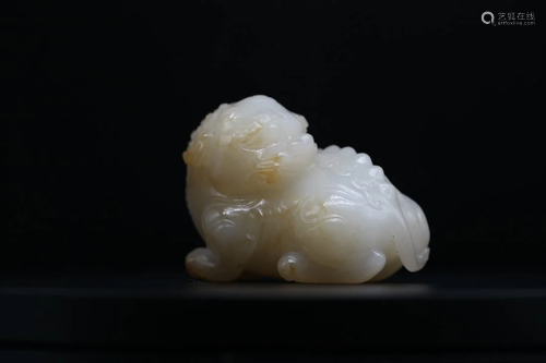 A WHITE JADE WITH YELLOW SKIN CARVING OF A BUDDHISH LION, Qi...