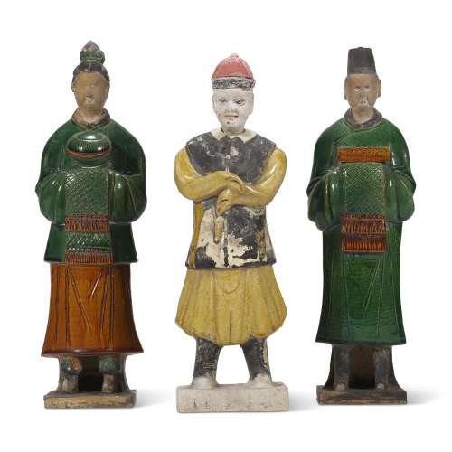 A YELLOW-GLAZED POTTERY FIGURE AND TWO GREEN AND AMBER-GLAZE...