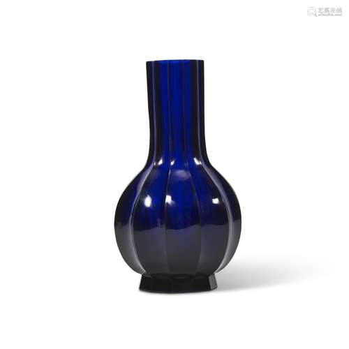 A TRANSLUCENT BLUE GLASS FLUTED BOTTLE VASE