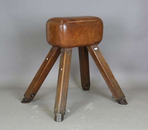 An early 20th century pommel horse with brown leather body a...