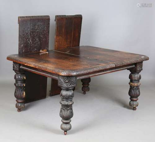 A late Victorian carved oak extending dining table, the top ...