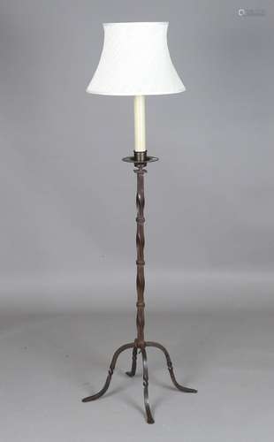 A 20th century patinated wrought iron lamp standard, the wry...