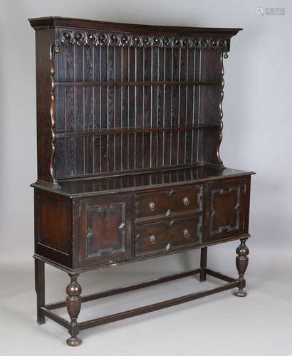 A George V oak dresser with carved foliate frieze and open s...