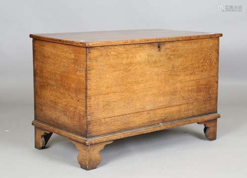 An early 19th century oak trunk with hinged lid and bracket ...