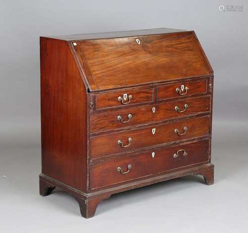 A George III mahogany bureau, the fall flap revealing a fitt...