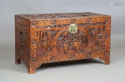 An early 20th century Chinese camphor trunk, carved in relie...