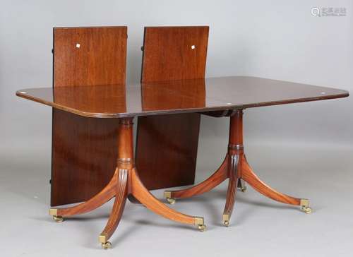 A 20th century Regency style mahogany dining table with two ...