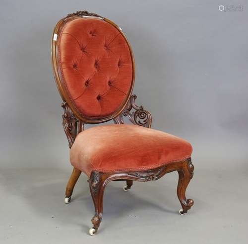 A Victorian mahogany carved showframe settee, upholstered in...