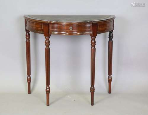 A modern reproduction mahogany side table, inset with a gree...