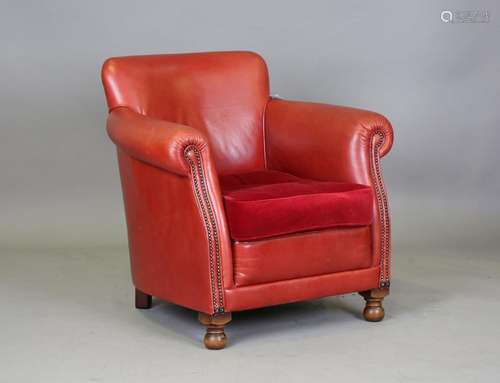 A modern red leather club armchair with brass studded front ...