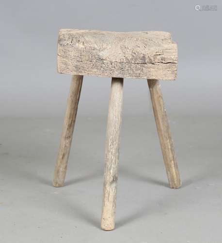 A 19th century primitive chopping block stool, on three stak...