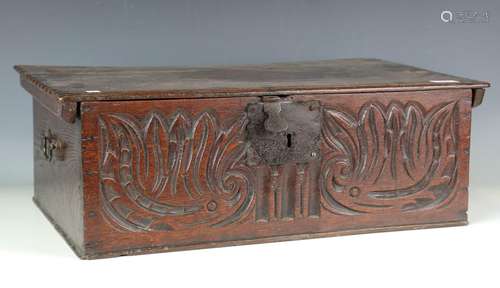 A 17th century oak bible box, the hinged lid above a foliate...