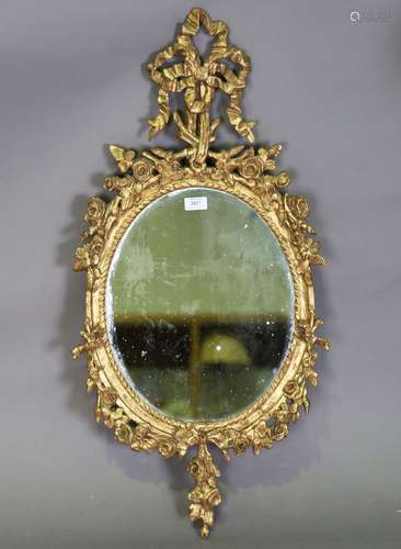 A 20th century giltwood and gesso oval wall mirror with ribb...