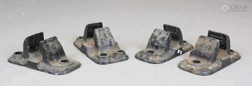 A group of four cast iron railway track shoes