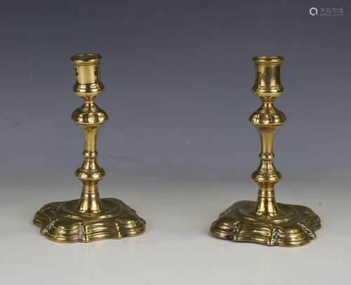 A pair of early 18th century brass candlesticks